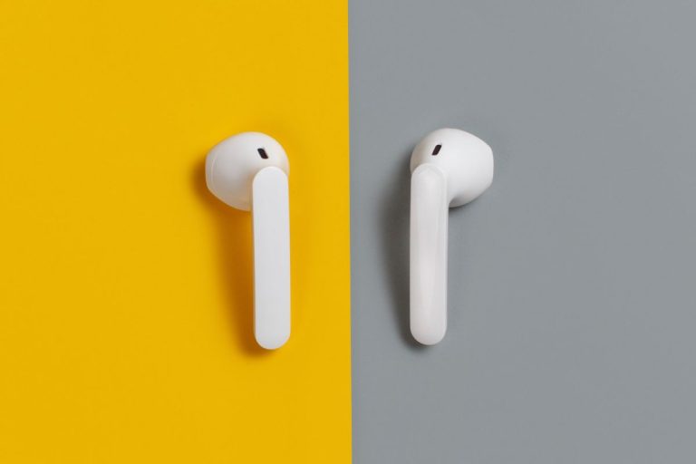 Earbuds on yellow and grey background