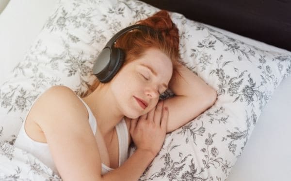 Woman sleeping peacefully with noise cancelling headphones on