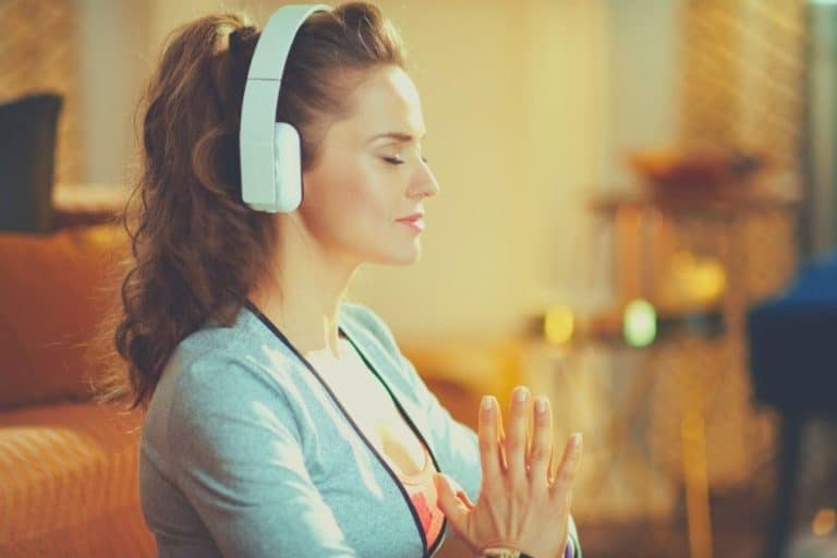 Woman meditating with white headphones